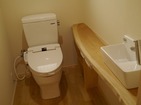 トイレのスペースを広めにとり、けやきの一枚板で手洗カウンターと収納を作りました。